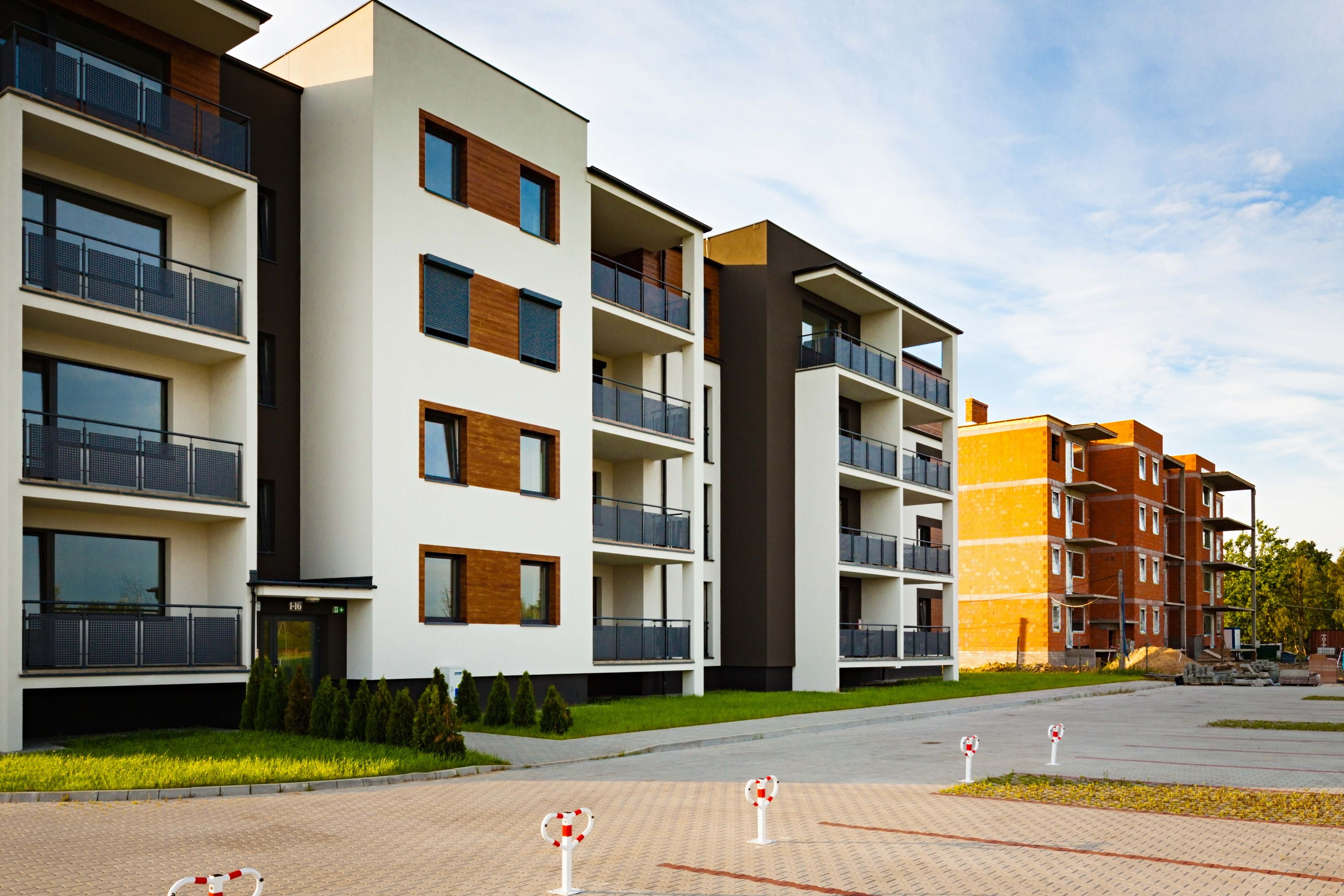 Habitational risks, New multi-family block with balconies and bright facade decorated with wood paneling.